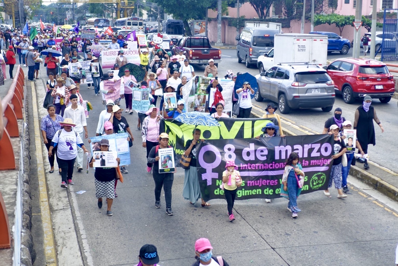 Women march next to a MOVIR banner holding pictures of incarcerated family members