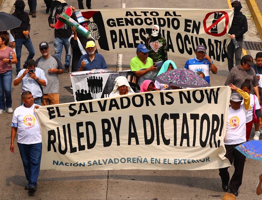 May Day marchers with a banner that says "El Salvador is now Ruled by a Dictator"