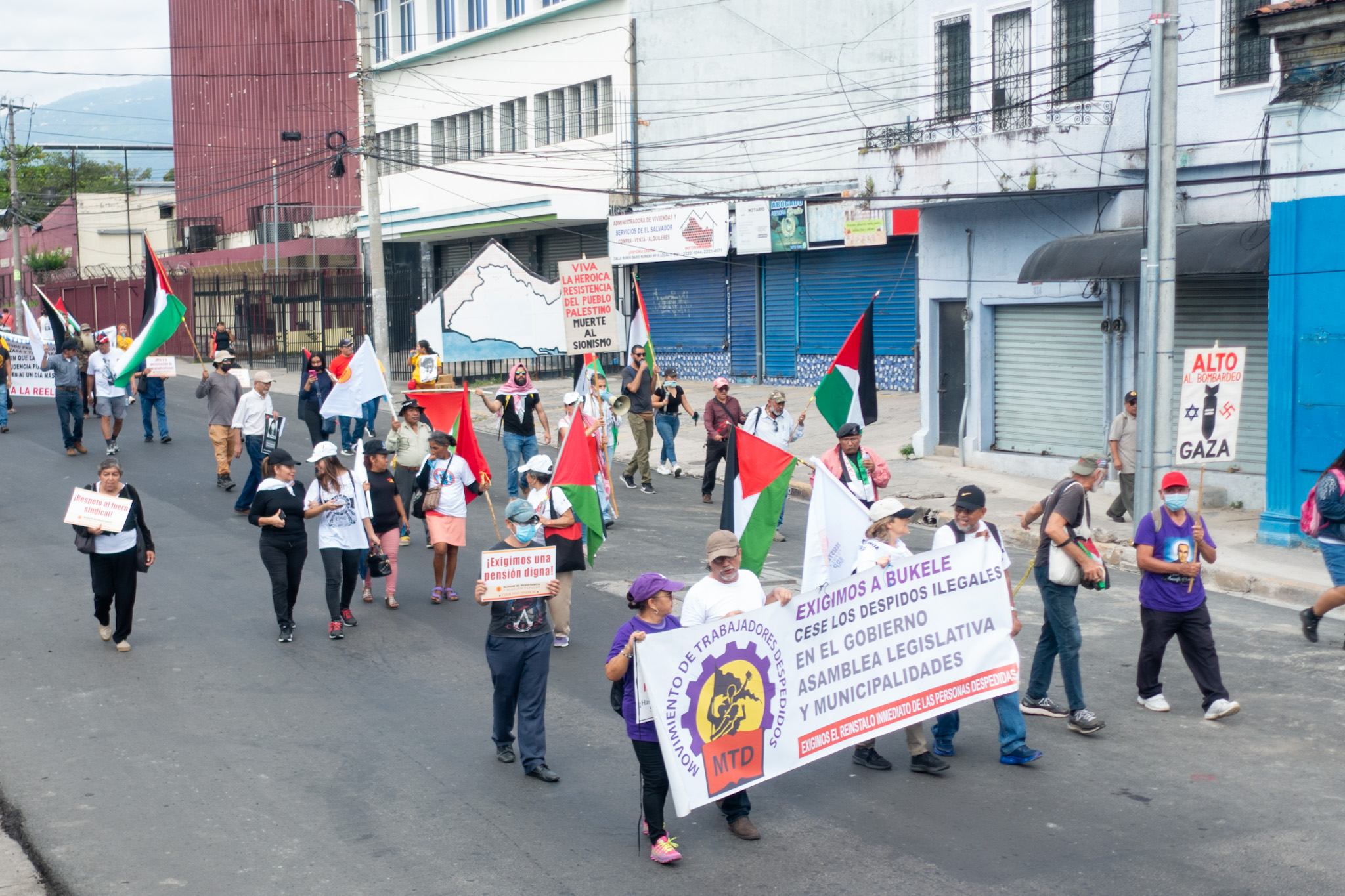 Fired Workers Movement members march with banner