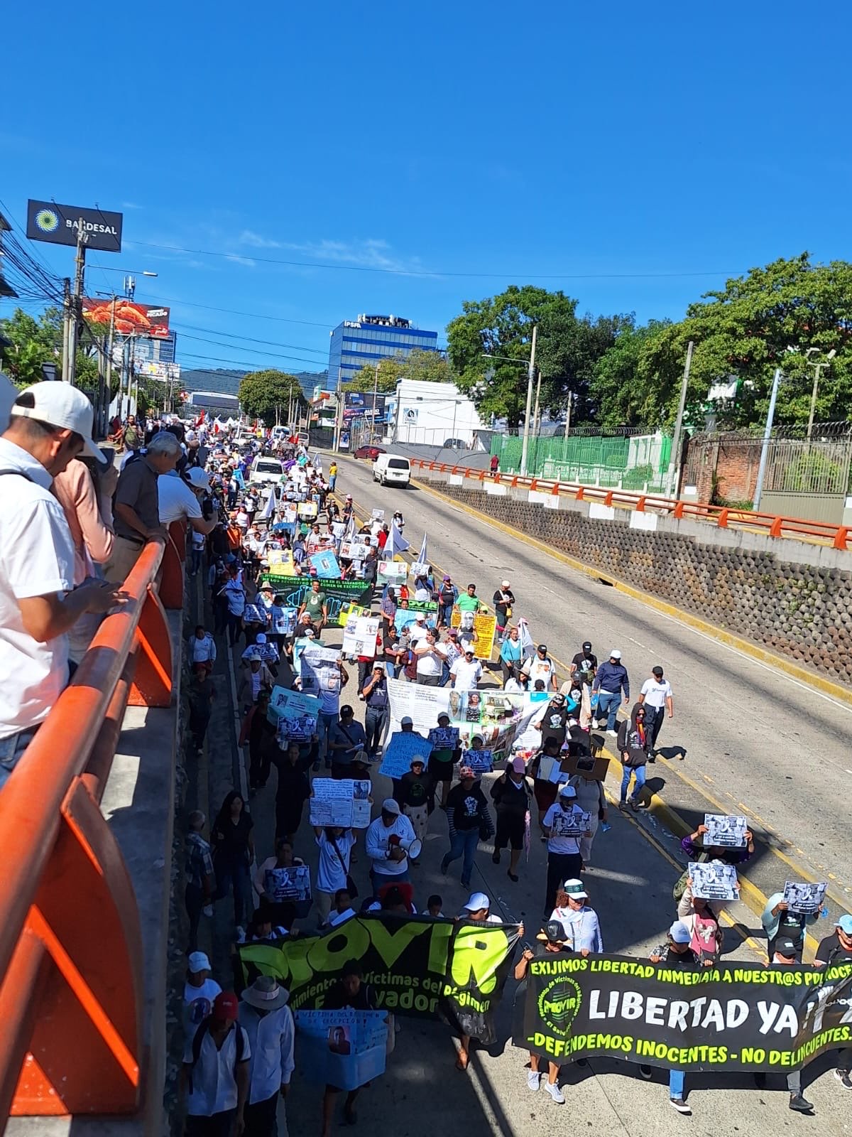 Marchers, dressed in white, march with signs and banners of loved ones detained during State of Exception