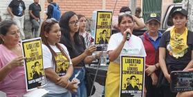 Women from Santa Marta community hold protest signs