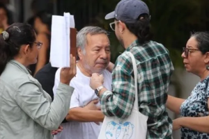 Atilio Montalvo, in a white t-shirt, reaches towards three family members to hug them